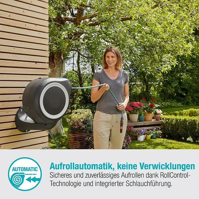 Gardena Wand-Schlauchbox RollUp S - Schlauchlänge: 15 m - Die Gardena Roll-up Automatik-Schlauchbox an einer Holzwand mit einer Frau, die den Gartenschlauch hält, im Hintergrund ein Garten.