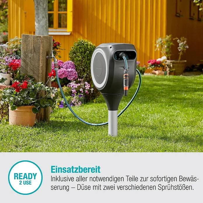 Gardena Schlauchbox RollUp M - Schlauchlänge: 20 m - Bild einer Gardena Wand-Schlauchbox RollUp S mit Gartenschlauch und Sprühdüse, bereit für die Bewässerung im Garten.