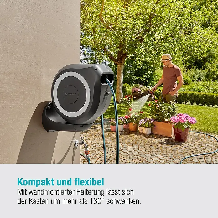 Gardena Wand-Schlauchbox RollUp M - Schlauchlänge: 20 m - Das Bild zeigt eine Gardena Schlauchbox an einer Wand, während ein Mann im Hintergrund Blumen gießt.