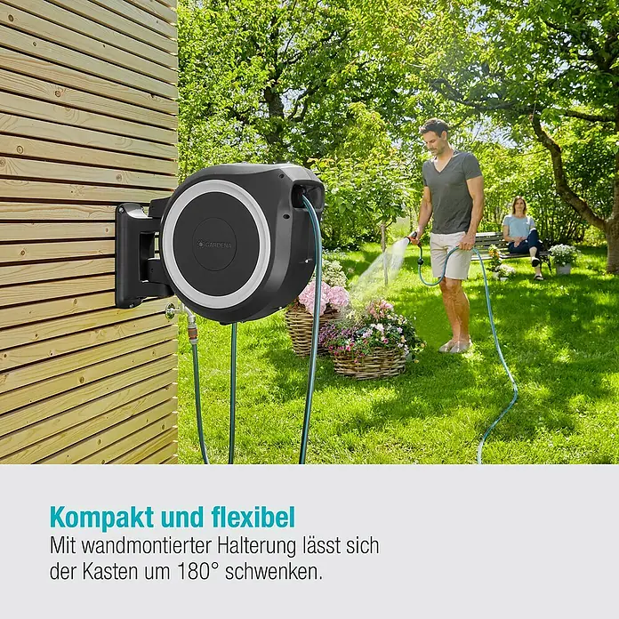 Gardena Wand-Schlauchbox RollUp XL - Schlauchlänge: 35 m - Wandmontierter Gartenschlauchaufroller von Gardena mit Schlauch. Ein Mann bewässert Blumen mit dem Schlauch, eine Frau sitzt im Hintergrund.