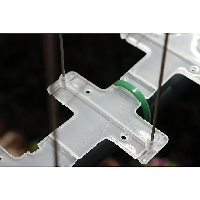 Altadex Sistema antipalomas - Largo: 200 cm, Acero - Primer plano de un soporte de plástico transparente asegurado con una goma verde y pasadores de metal, ideal para proyectos de manualidades.