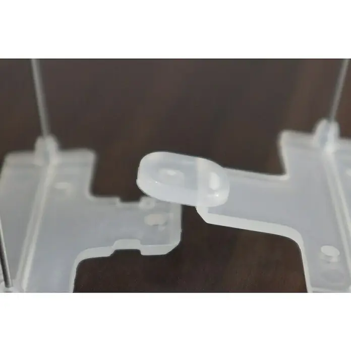 Altadex Sistema antipalomas - Largo: 200 cm, Acero - Primer plano de una pieza de plástico transparente con un botón redondeado, probablemente parte de un dispositivo o soporte.