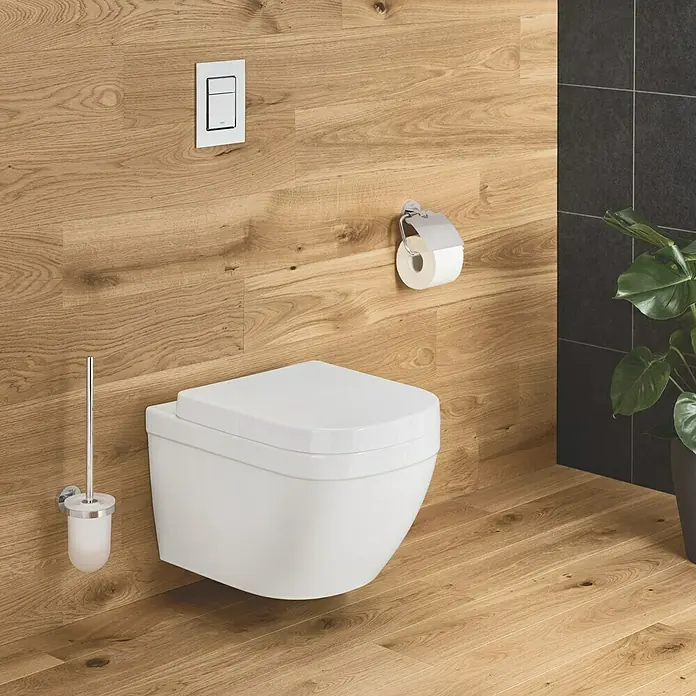 Grohe Essentials WC-Bürstengarnitur - Mit Halterung, Chrom, Glänzend - Bild einer modernen, wandhängenden Toilette in einem Badezimmer mit Holzverkleidung, das ein minimalistisches Design aufweist.