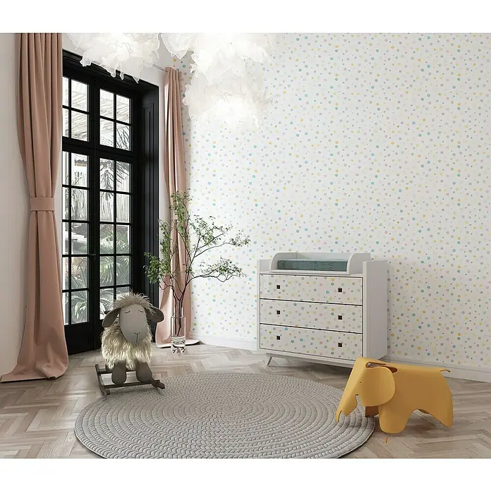 Papel pintado de vinilo adhesivo Lineawall - Confeti, 90 cm x 2,8 m - Habitación infantil con cambiador, balancín de oveja y silla de elefante frente a una pared de lunares.