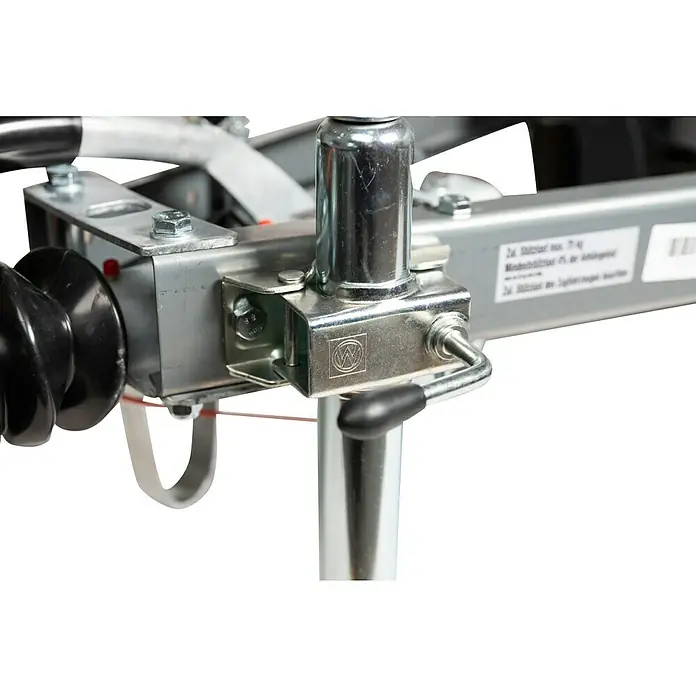 Stema Anhänger Mini 750G R10 mit Stützrad u. Stoßdämpfer - Nutzlast: 621 kg, Einachser, Kasteninnenmaß: 134 x 108 x 26,5 cm, Gebremst - Nahaufnahme eines Anhängers mit einer stabilen Stütze mit dem VW-Logo, befestigt an einem silbernen Rahmen mit Schrauben.