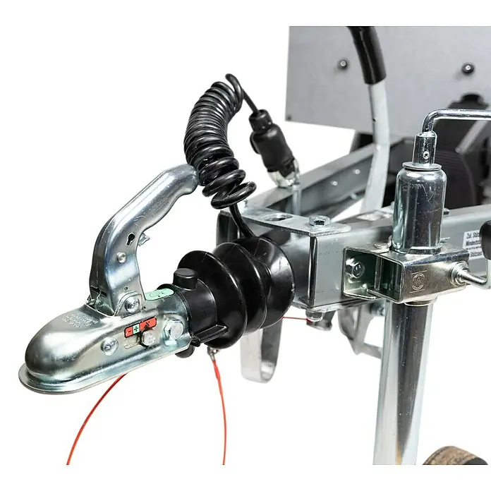 Stema Anhänger Mini 750G R10 mit Stützrad u. Stoßdämpfer - Nutzlast: 621 kg, Einachser, Kasteninnenmaß: 134 x 108 x 26,5 cm, Gebremst - Nahaufnahme einer Anhängerkupplung mit schwarzem Faltenbalg und Spiralkabel. Robuste Konstruktion für sicheren Transport.
