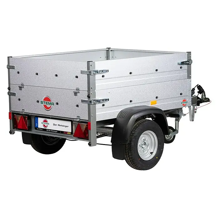 Stema Anhänger Mini 750 G R10 mit Bordwandaufsatz, Flachplane, Stützrad u. Stoßdämpfer - Nutzlast: 596 kg, Einachser, Kasteninnenmaß: 134 x 108 x 26,5 cm (Höhe inkl. Bordwandaufsatz 53 cm), Gebremst - Ein Stema Anhänger mit silbernen Wänden und schwarzen Radkästen, der auf einem schwarzen Hintergrund steht, um das Produkt hervorzuheben.