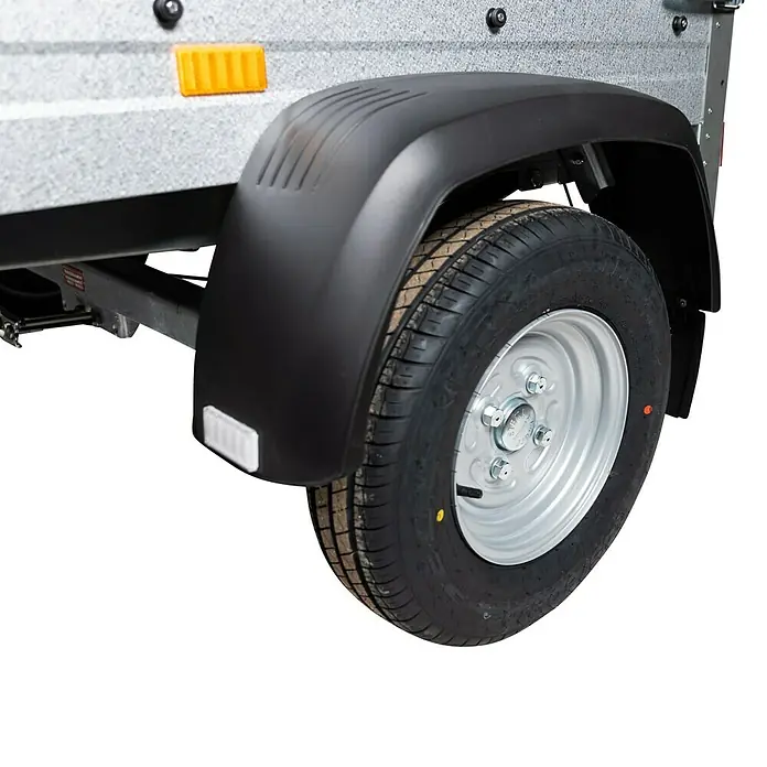 Stema Anhänger Mini 750G R10 mit Stützrad u. Stoßdämpfer - Nutzlast: 621 kg, Einachser, Kasteninnenmaß: 134 x 108 x 26,5 cm, Gebremst - Nahaufnahme eines Anhängers mit schwarzem Kotflügel und silberner Felge, ideal für den sicheren Transport.