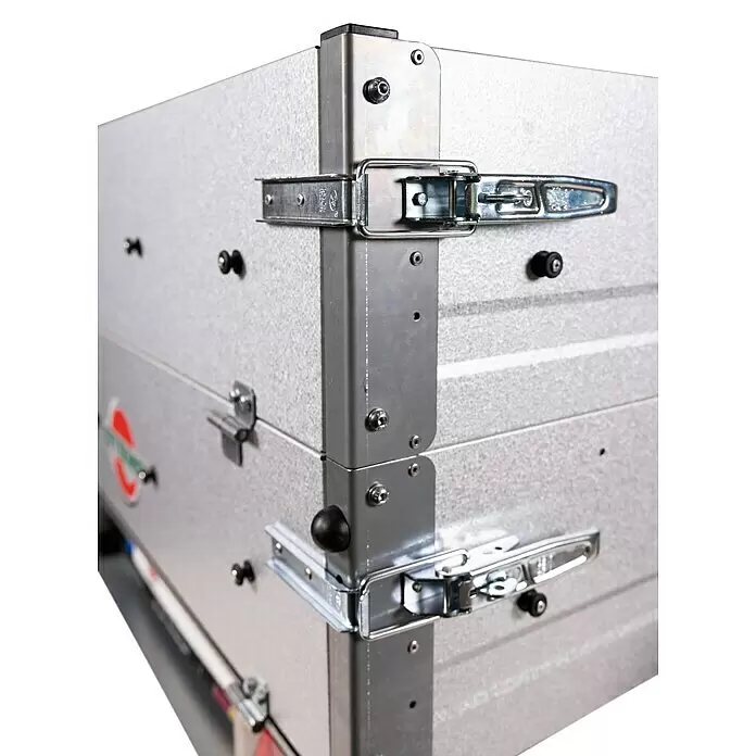 Stema Anhänger Mini 350 mit Bordwandaufsatz u. Flachplane - Nutzlast: 245 kg, Einachser, Kasteninnenmaß: 134 x 108 x 26,5 cm (Höhe inkl. Bordwandaufsatz 53 cm), Ungebremst - Nahaufnahme einer Ecke einer verzinkten Metallbox mit mehreren silbernen Verschlüssen und der texturierten Oberfläche.