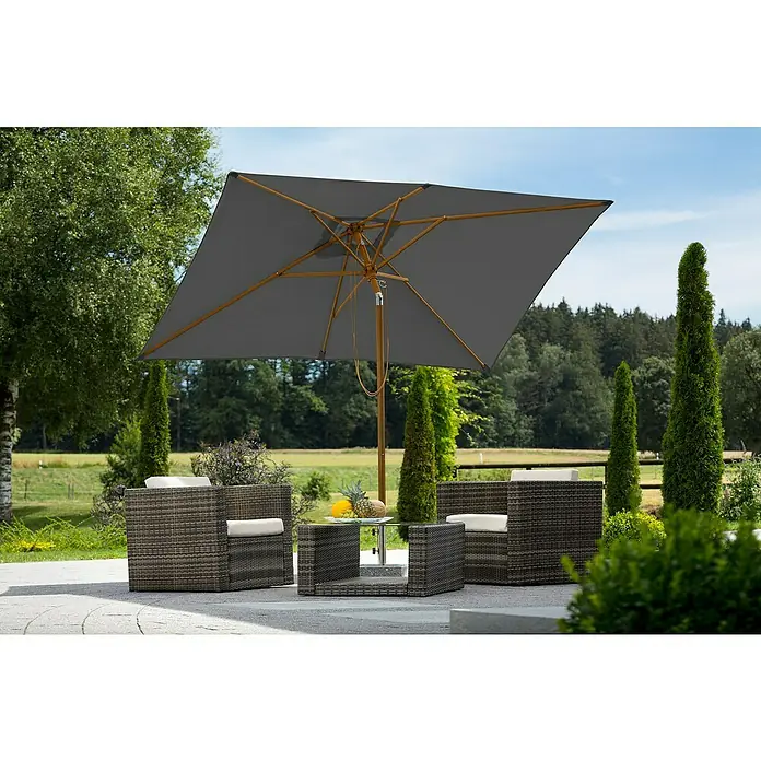 Schneider Classic Marktschirm Malaga - Anthrazit, Bespannungsmaß (L x B): 300 x 200 cm - Ein grauer Gartenschirm spendet Schatten über einem stilvollen Outdoor-Sitzbereich mit Rattansesseln und einem Glastisch, umgeben von üppigem Grün.