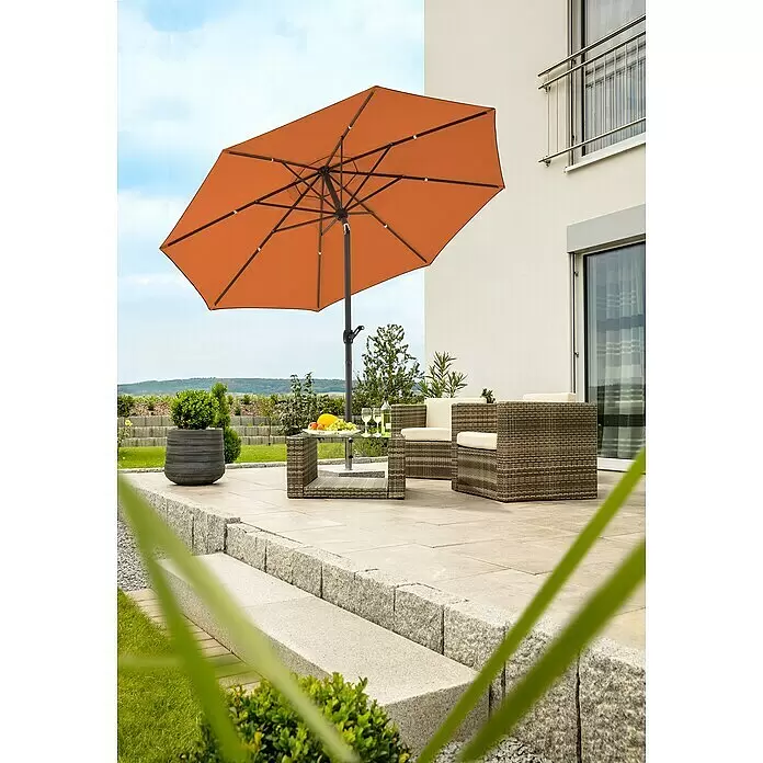 Schneider Classic Marktschirm rund Adria - Terracotta, Durchmesser Bespannung: 300 cm - Ein orangefarbener Sonnenschirm spendet Schatten über Gartenmöbeln auf einer Terrasse.