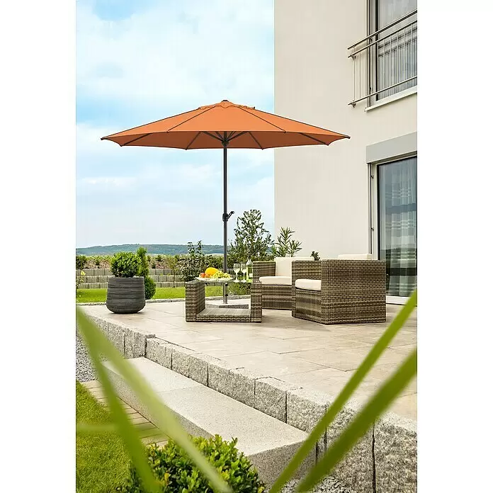 Schneider Classic Marktschirm rund Adria - Terracotta, Durchmesser Bespannung: 350 cm - Ein Outdoor-Geflechtmöbel-Set mit cremefarbenen Kissen, orangefarbenem Sonnenschirm und einem Glastisch mit Obst und Wein auf einer Terrasse.