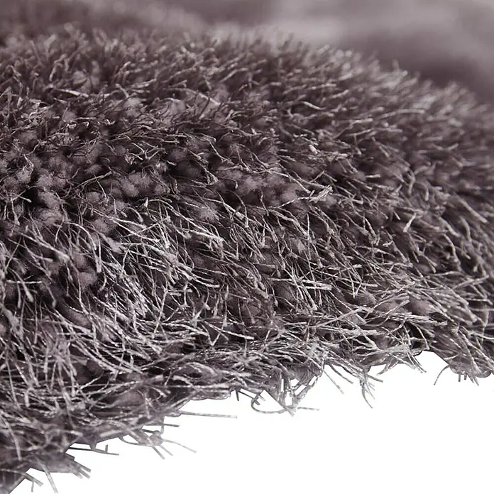 Kayoom Hochflorteppich CosySilber, 230 x 160 cm, 100 % Polyester - Detailaufnahme eines hochflorigen, flauschigen Teppichs in einer dezenten Farbe. Die Textur lädt zum Berühren ein.