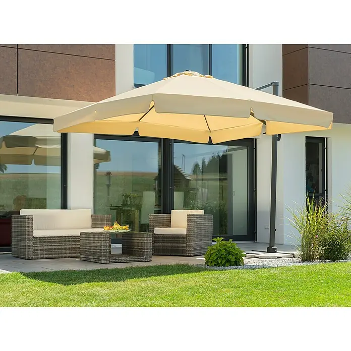 Schneider Classic Ampelschirm Rhodos - Natur, Bespannungsmaß (L x B): 300 x 300 cm - Ein großer, beigefarbener Sonnenschirm überspannt eine stilvolle Terrassengarnitur mit Rattansesseln und einem Couchtisch, ideal für entspannte Stunden im Freien.
