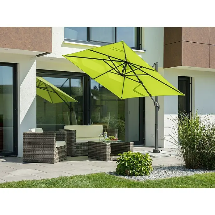 Schneider Classic Ampelschirm Rhodos Junior - Apfelgrün, Bespannungsmaß (L x B): 230 x 230 cm - Ein sonnengelber Ampelschirm spendet Schatten über einer Terrassengarnitur mit Rattansesseln und Couchtisch.
