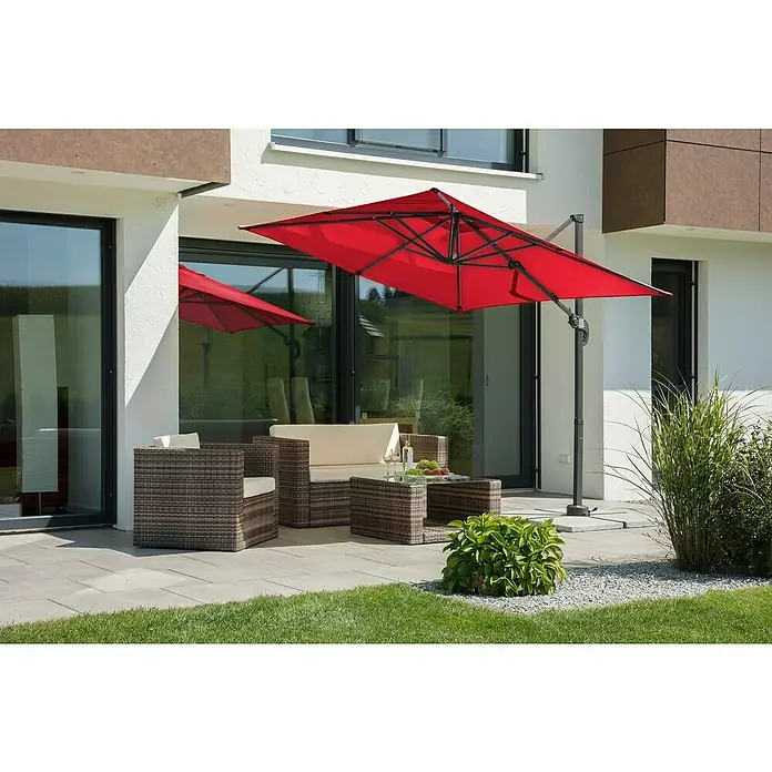 Schneider Classic Ampelschirm Rhodos Junior - Rot, Bespannungsmaß (L x B): 230 x 230 cm - Eine Gartenszene mit einem roten Ampelschirm, der Schatten auf die Rattansitzgruppe wirft, die zum Entspannen im Freien einlädt.