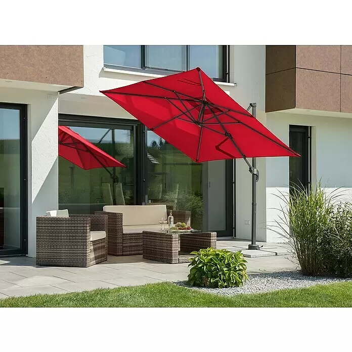 Schneider Classic Ampelschirm Rhodos Junior - Rot, Bespannungsmaß (L x B): 230 x 230 cm - Großer roter Ampelschirm spendet Schatten über einer modernen Terrasse mit dunklen Loungemöbeln und Pflanzen.