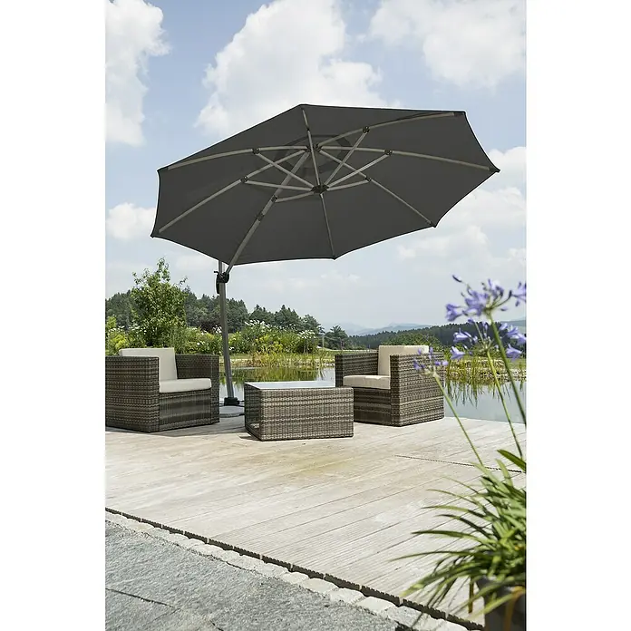Schneider Classic Ampelschirm rund Rhondos Rondo - Anthrazit, Durchmesser Bespannung: 350 cm - Ein grauer Sonnenschirm spendet Schatten über zwei Korbsesseln und einem Tisch auf einer Holzterrasse, ideal für entspannte Stunden im Freien.