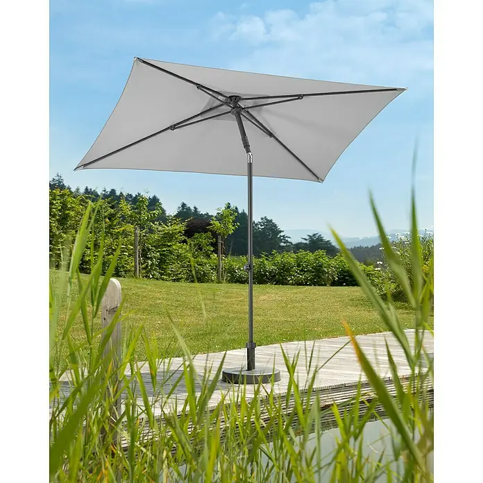 Schneider Classic Marktschirm Sevilla - Silbergrau, Bespannungsmaß (L x B): 240 x 140 cm - Ein grauer, rechteckiger Sonnenschirm steht auf einer Holzterrasse, umgeben von Grün und bietet Schatten an einem sonnigen Tag.