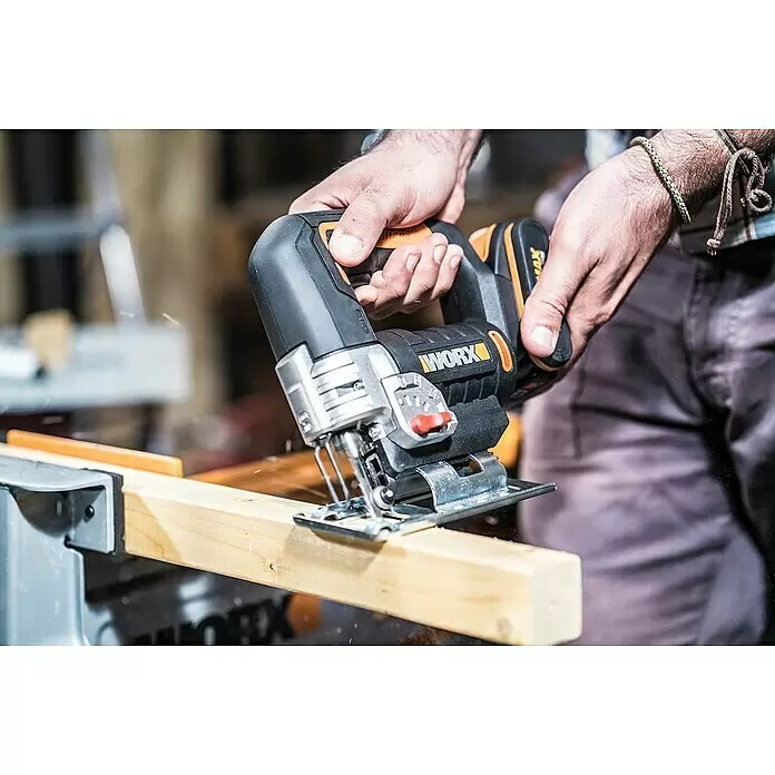 Worx PowerShare 20V Akku-Stichsäge WX543 - 20 V, 1 Akku, 2 Ah, Leerlaufhubzahl: 0 /min - 2.600 /min - Person schneidet mit einer schwarz-orangen Worx Stichsäge ein Holzstück. Sägespäne sind sichtbar.