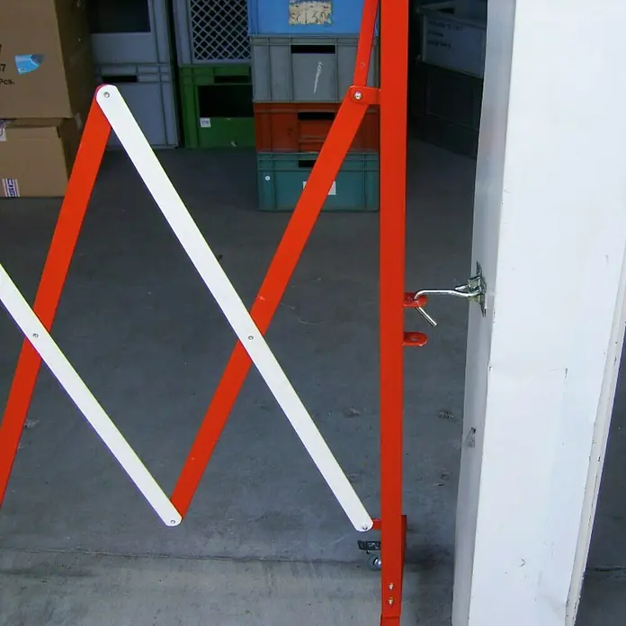 Surtido de clips de sujeción - Robusto - Una barrera de puerta de tijera roja y blanca, fijada a una columna blanca, se utiliza para el control de acceso temporal.