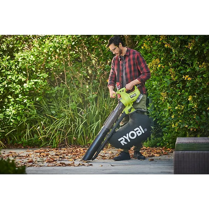 Ryobi ONE+HP Akku-Laubsauger & -Laubbläser RY18BVXA-150 - 1 Akku, 5 Ah, Blasleistung: 1,8 m³/min, Blasgeschwindigkeit: 252 km/h - Ein Mann benutzt einen Ryobi Laubbläser im Garten, um Blätter zu entfernen. Der Laubbläser ist grün und schwarz und hat einen Auffangsack.