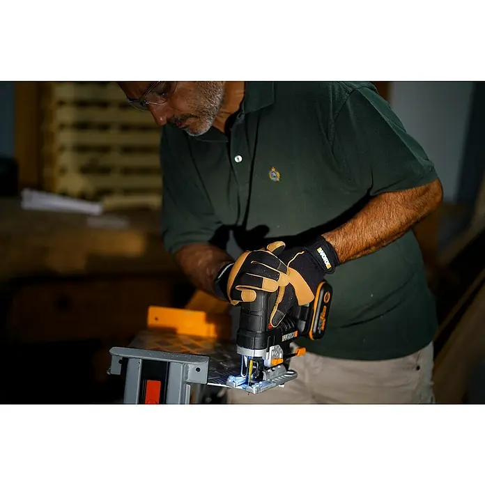 Worx PowerShare 20V Akku-Stichsäge WX542.9 - 20 V, Ohne Akku, Leerlaufhubzahl: 0 /min - 3.500 /min - Ein Mann benutzt eine WORX Stichsäge mit Akku und Handschuhen, um präzise Schnitte zu erzielen, während er an einem Projekt arbeitet.