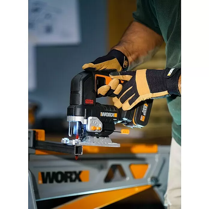 Worx PowerShare 20V Akku-Stichsäge WX542.9 - 20 V, Ohne Akku, Leerlaufhubzahl: 0 /min - 3.500 /min - Person in Arbeitshandschuhen schneidet Metallrohr mit schwarzer und oranger kabelloser Worx Stichsäge auf Worx Werkbank.