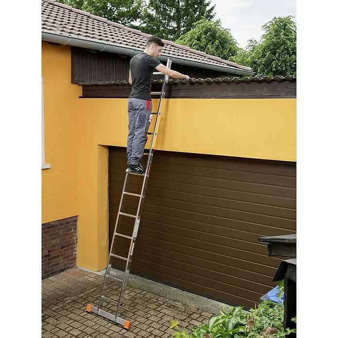 Krause Monto Anlegeleiter Sibilo - Anzahl Tritte: 12 Stk., Arbeitshöhe: 4,4 m, Aluminium - Mann auf einer Leiter, der an einem gelben Gebäude arbeitet. Die Leiter ist ein zentrales Element im Bild.
