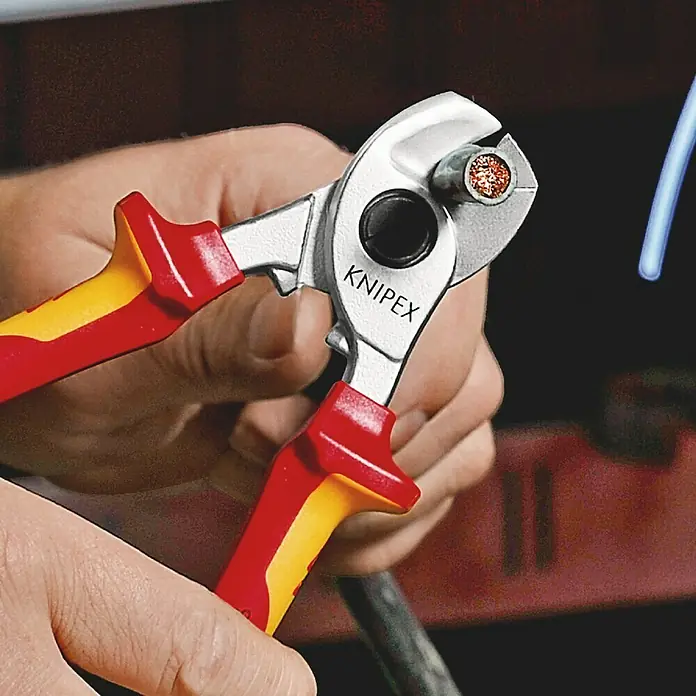 Knipex Kabelschere VDE - Länge: 165 mm - Nahaufnahme einer Knipex-Kabelschere mit rot-gelben Griffen, die ein Kabel durchtrennt, Fokus auf die Präzision des Werkzeugs.