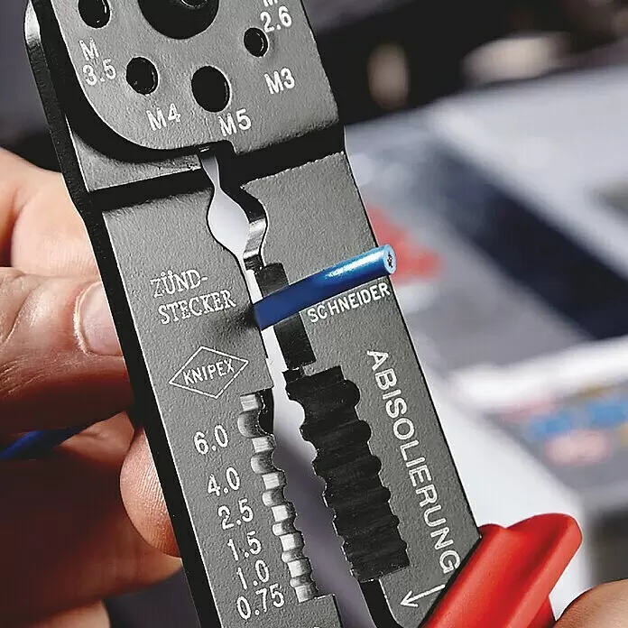 Knipex Crimpzange - Länge: 24 cm - Schwarzes Knipex Multifunktionswerkzeug mit roten Griffen, hält und isoliert ein blaues Kabel.