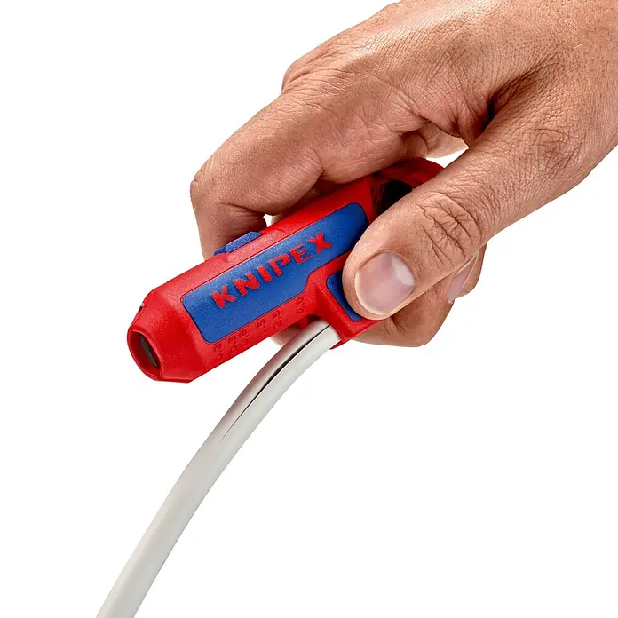 Knipex Abisolierzange - Passend für: 0,2/0,3/0,8/1,5/2,5/4 mm² Kabelquerschnitt - Die Hand hält eine Knipex Abisolierzange, die ein weißes Kabel abisoliert. Das Werkzeug ist rot und blau und präzise gefertigt.