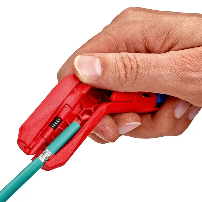 Knipex Abisolierzange - Passend für: 0,2/0,3/0,8/1,5/2,5/4 mm² Kabelquerschnitt - Eine Hand verwendet einen Knipex ErgoStrip, um ein Kabel zu schneiden. Der ErgoStrip ist rot und blau und hat ein ergonomisches Design.
