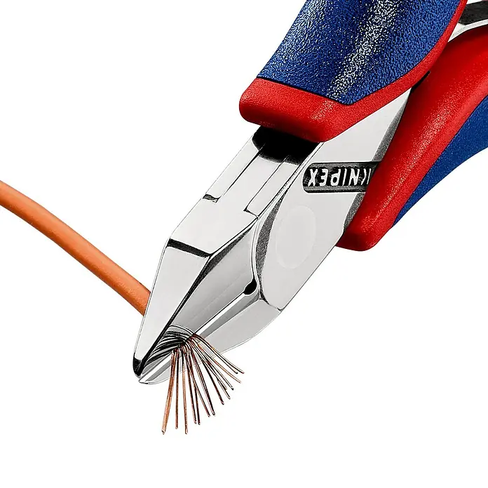 Knipex Seitenschneider - Länge: 11,5 cm, Härte Schneide: 60 HRC, Ölgehärtet, 0,3 mm - 1,3 mm - Knipex Seitenschneider schneidet ein orangefarbenes Kabel und zeigt freiliegende Kupferdrähte. Der Griff ist blau und rot.