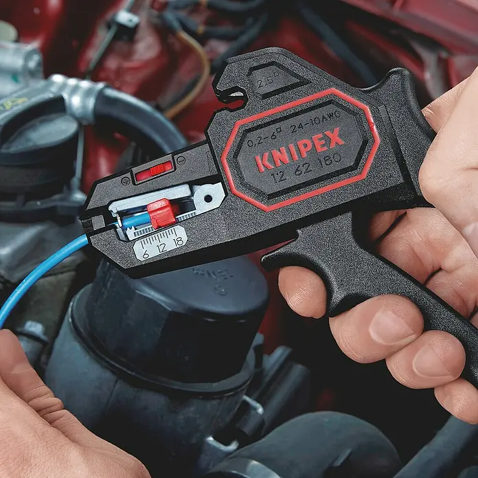 Knipex Abisolierzange - Länge: 18 cm - Eine Knipex Abisolierzange beim Bearbeiten eines blauen Kabels, ideal für präzises und müheloses Abisolieren verschiedener Kabeltypen.