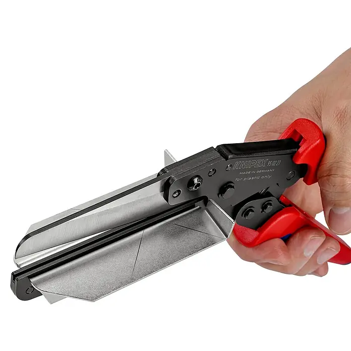 Knipex Schere - Geeignet für: Kunststoffprofile, Schnittlänge: 110 mm - Nahaufnahme einer KNIPEX 95 12 21 Schere zum Schneiden von Plastik, gehalten in einer Hand vor schwarzem Hintergrund.