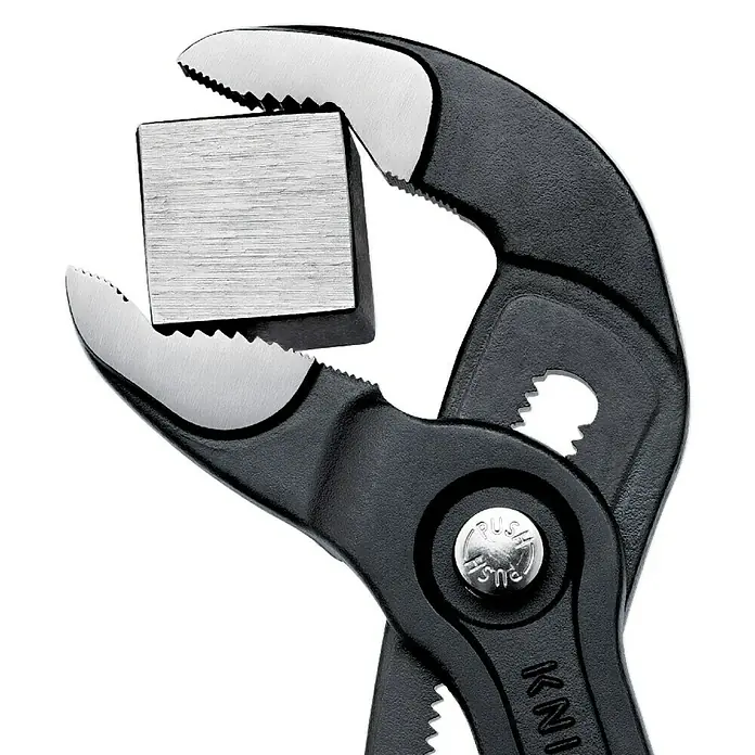 Knipex Wasserpumpenzange Cobra - Länge: 250 mm - Die Knipex Zange, ein hochwertiges Werkzeug, hält einen Metallwürfel fest im Griff, ideal für präzise Arbeiten.