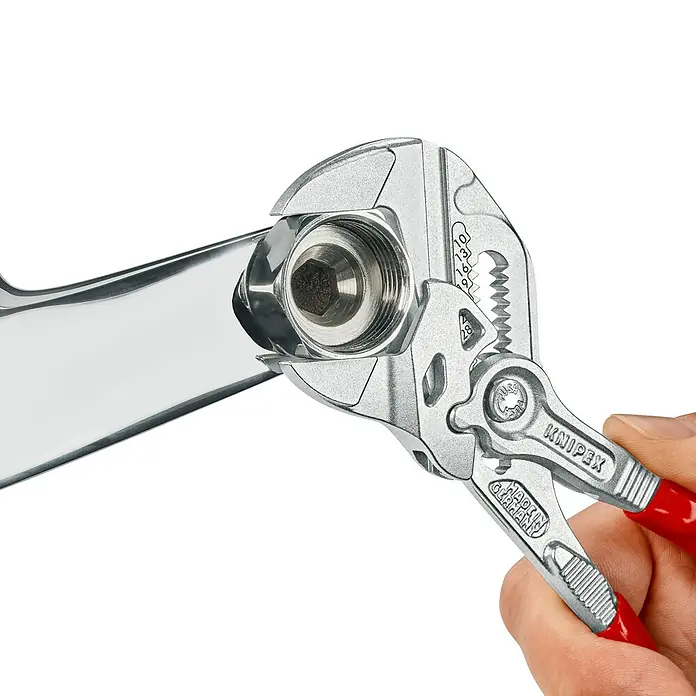 Knipex Wasserpumpenzange - Länge: 180 mm, Verchromt - Eine Knipex Rohrzange im Einsatz, die ein silbernes Rohrteil greift, mit roten Griffen und der Aufschrift "Made in Germany".