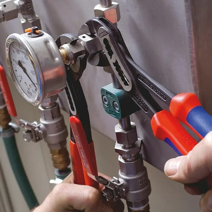 Knipex Wasserpumpenzange Alligator - Länge: 250 mm, Poliert - Nahaufnahme von Knipex Alligator-Wasserpumpenzangen im Einsatz, die an einer Installation arbeiten.