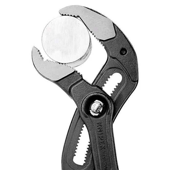 Knipex Wasserpumpenzange Cobra XL - Max. Backenöffnung: 95 mm, Länge: 445 mm, Rot - Eine Nahaufnahme einer schwarzen Knipex-Rohrzange, die ein rundes Metallstück hält, wobei die gezackten Backen die Oberfläche greifen.