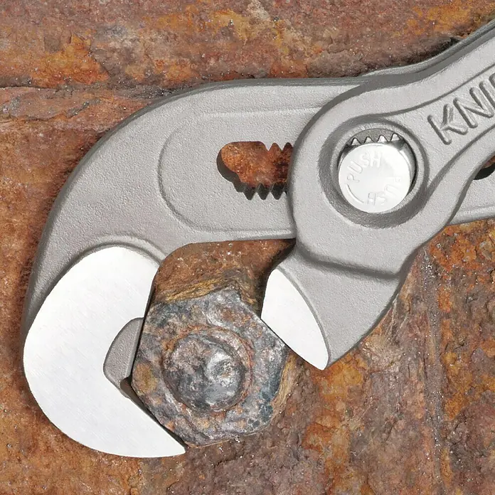 Knipex Schraubzange - Länge: 25 cm - Nahaufnahme einer Knipex Zange, die eine verrostete Schraube auf einem braunen Untergrund hält.