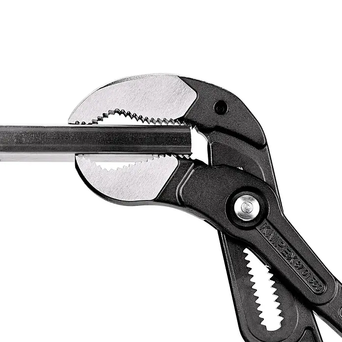 Knipex Wasserpumpenzange Cobra XXL - Max. Backenöffnung: 120 mm, Länge: 560 mm, Rot - Knipex Zange hält ein Metallrohr fest, wodurch ihre robuste Bauweise und Funktionalität hervorgehoben wird. Ideal für Handwerker.