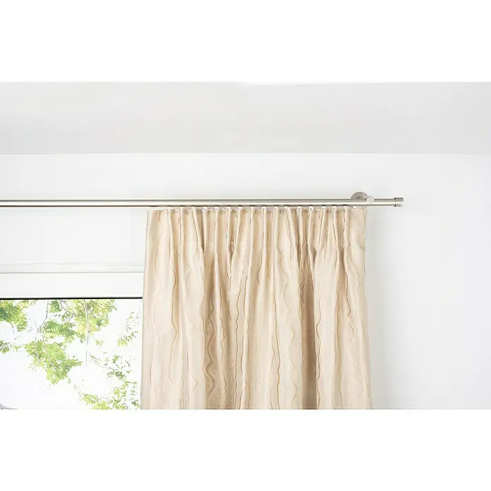 Schlaufenschal Stream - B x H: 135 x 245 cm, 100 % Polyester, Sand - Ein cremefarbener Vorhang hängt an einer silbernen Gardinenstange, der das Licht elegant filtert und eine warme Atmosphäre erzeugt.