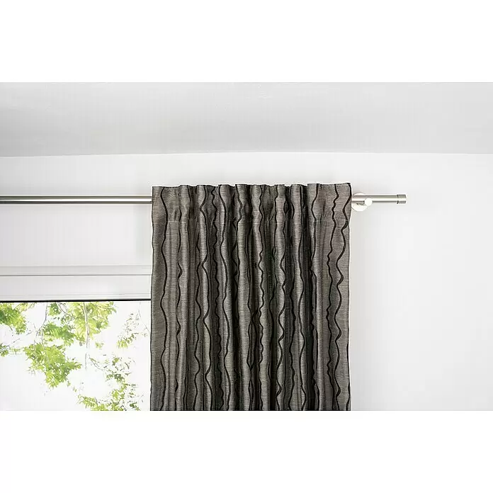 Schlaufenschal Stream - B x H: 135 x 300 cm, 100 % Polyester, Taupe - Ein dunkelgrauer Vorhang mit schwarzen Wellenmustern hängt an einer silbernen Stange und bedeckt teilweise ein Fenster.