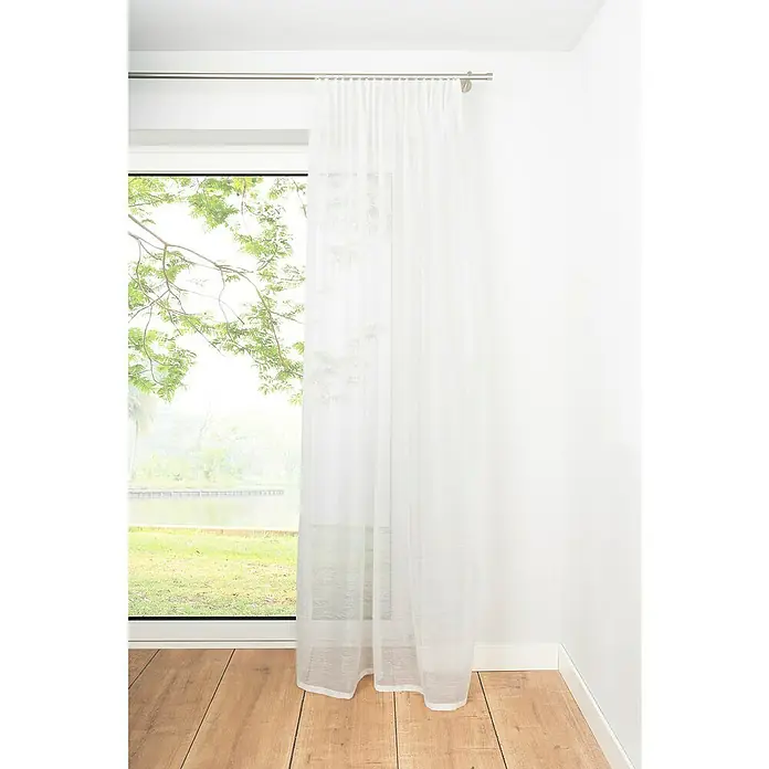 Schlaufenschal Soft - B x H: 135 x 245 cm, 100 % Polyester, Weiß - Weißer, lichtdurchlässiger Vorhang vor einem Fenster mit Blick ins Grüne, der eine helle und luftige Atmosphäre erzeugt.
