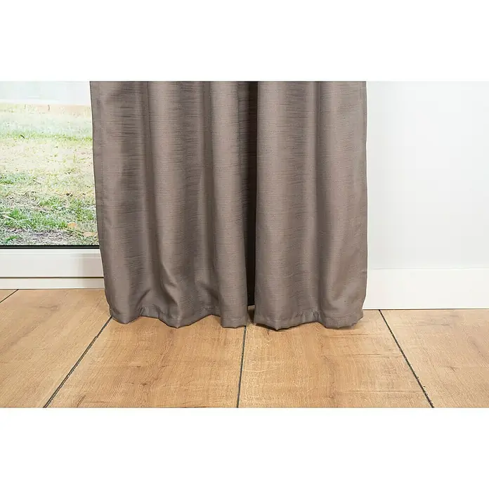 Schlaufenschal Leinen-Look - B x H: 135 x 245 cm, 100 % Polyester, Taupe - Nahaufnahme von eleganten Vorhängen, die ein Fenster teilweise verdecken und den Raum abdunkeln. Der Boden besteht aus hellem Holz.