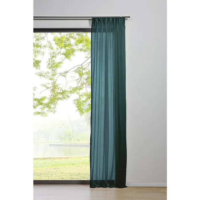Schlaufenschal Transparent - B x H: 135 x 300 cm, 100 % Polyester, Türkis - Eine lange, grüne Gardine hängt an einer Gardinenstange vor einem Fenster mit Blick auf eine grüne Landschaft.