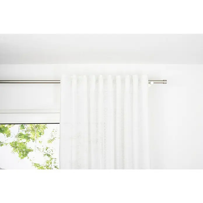 Schlaufenschal Dot - B x H: 135 x 245 cm, 100 % Polyester, Weiß - Das Bild zeigt einen weißen Vorhang, der an einer silbernen Gardinenstange hängt und ein Fenster teilweise verdeckt. Er sorgt für Privatsphäre und Lichtfilterung.