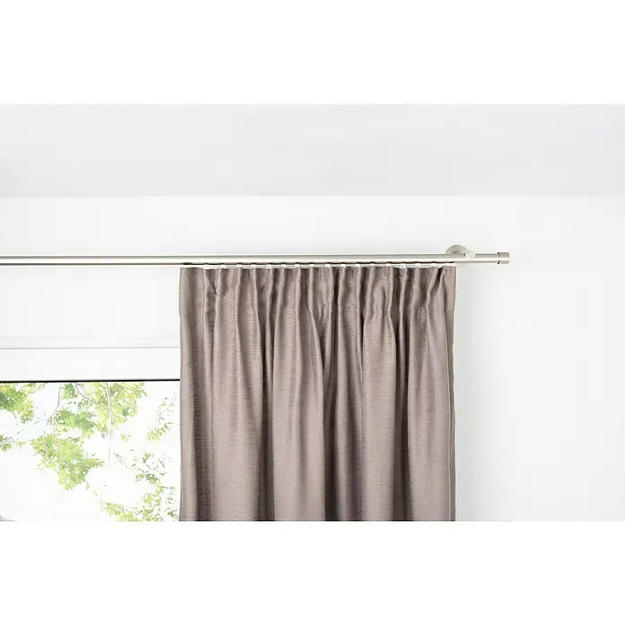 Schlaufenschal Leinen-Look - B x H: 135 x 245 cm, 100 % Polyester, Taupe - Ein schicker, grauer Vorhang hängt an einer silbernen Gardinenstange vor einem Fenster und verleiht dem Raum einen Hauch von Eleganz und Privatsphäre.