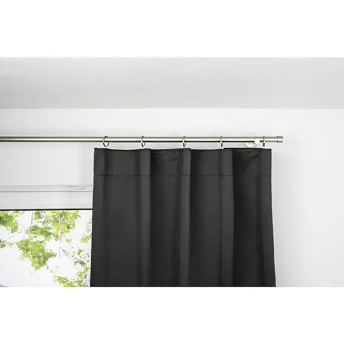 Schlaufenschal Day & Night - B x H: 135 x 300 cm, 100 % Polyester, Schwarz - Nahaufnahme eines Blackout-Vorhangs in Schwarz, der an einer silbernen Gardinenstange hängt und das Tageslicht effektiv abschirmt.